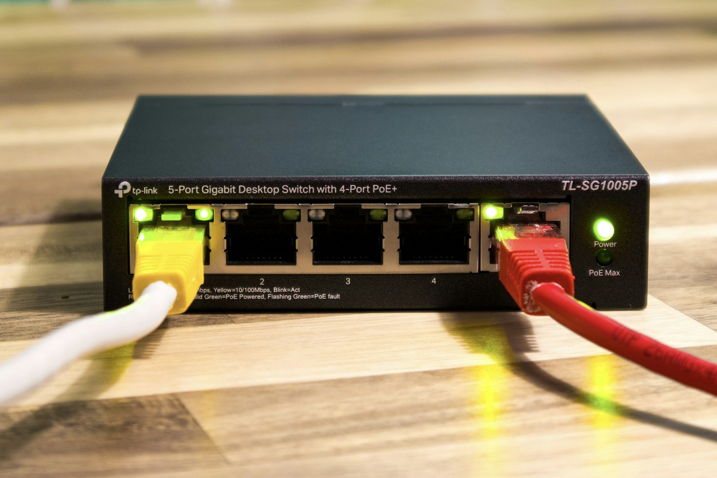 A desktop PoE switch with connected Ethernet cables