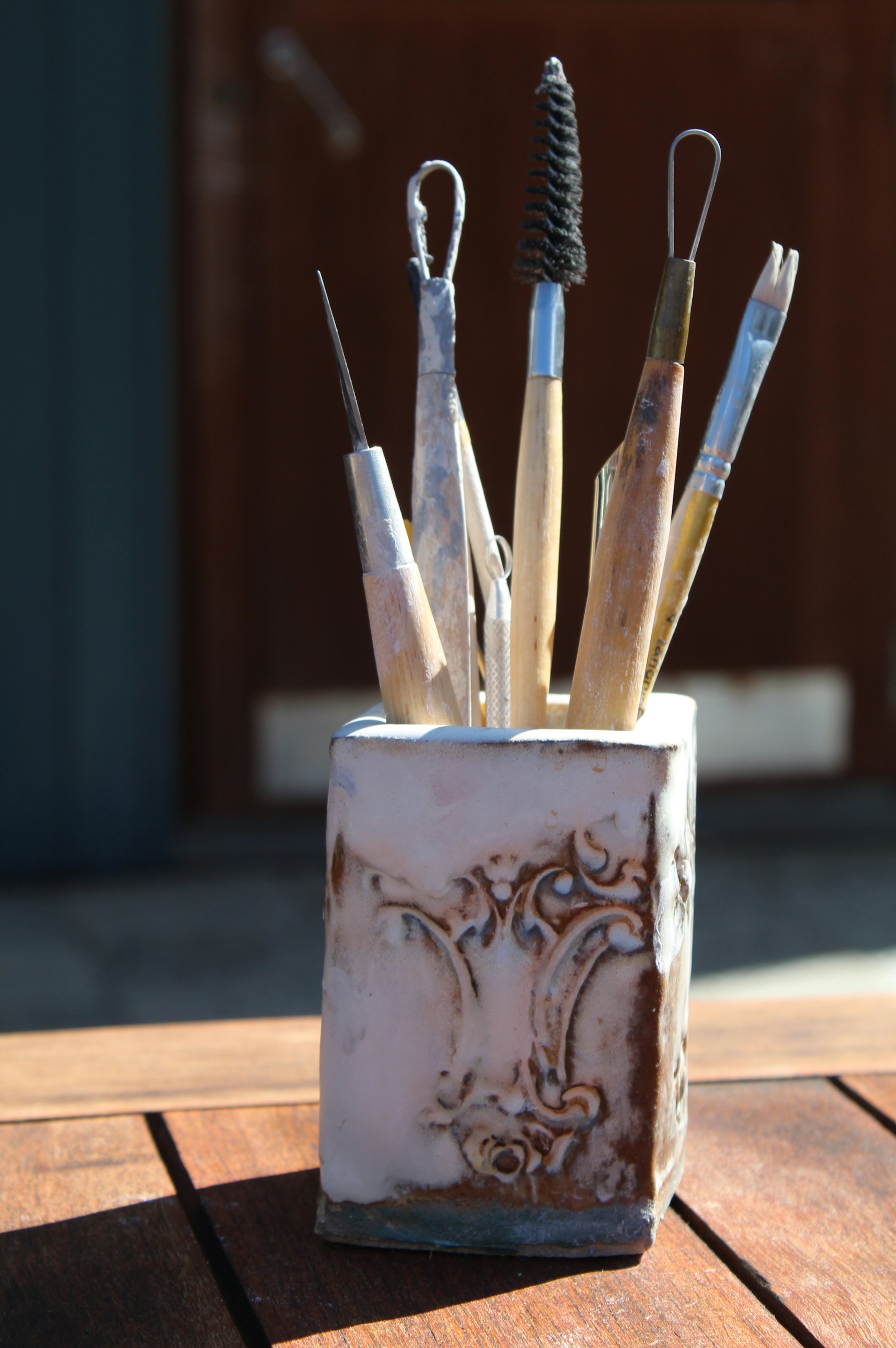 Ceramic vessels holding brushes and studio tools